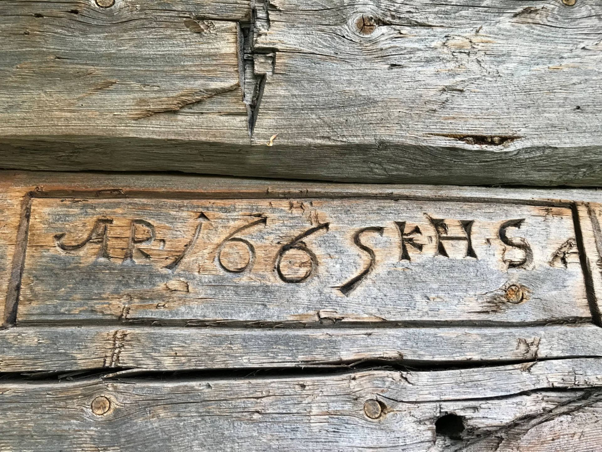 Innskore årstal 1665 i ein tømmerstokk i årestova