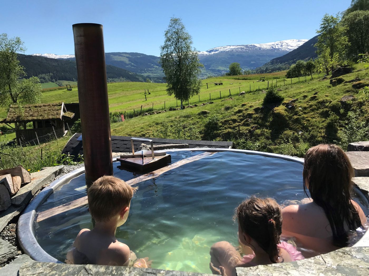 Born i den vedfyrte badestampen med utsikt over dalen